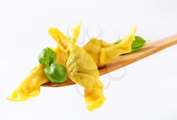 Caramelle shaped stuffed pasta on wooden spatula