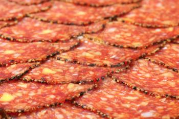 Thin slices of black pepper-coated salami speckled with pieces of Comte cheese