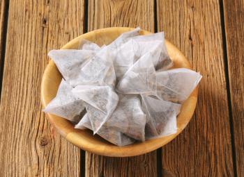 Pyramid-shaped jasmine tea bags in wooden bowl