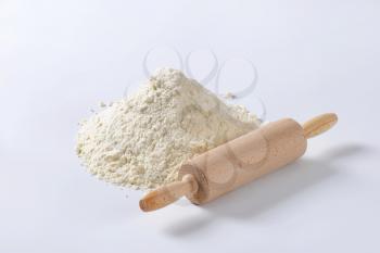 Wooden roller type rolling pin and pile of finely ground flour
