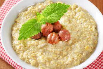Bowl of white oats porridge with hazelnuts