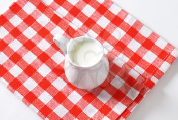 pitcher of milk on checked napkin