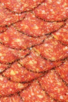 Black pepper-coated salami speckled with pieces of Comte cheese - thinly sliced