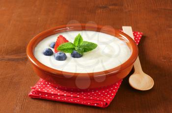 Smooth semolina porridge served in terracotta dish with fresh fruit