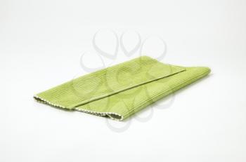 Folded light green place mat on white background