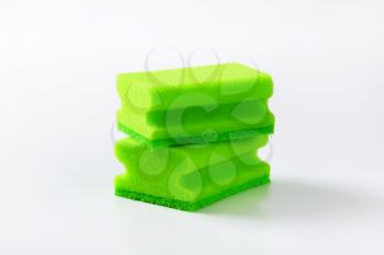 two green kitchen sponges with scouring pad