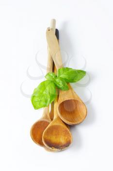 three old wooden spoons on off-white background