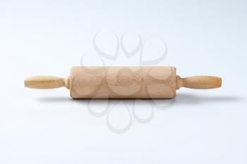 wooden rolling pin on off-white background