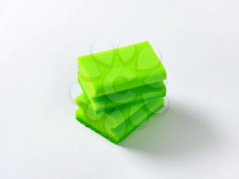 two green kitchen sponges with scouring pad