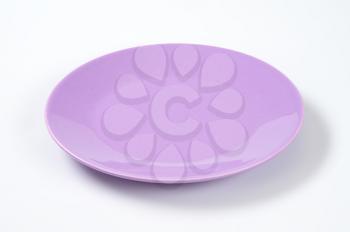 empty violet plate on off-white background
