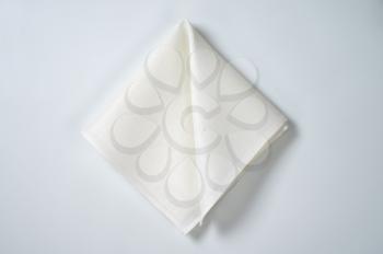 white cloth napkin on off-white background