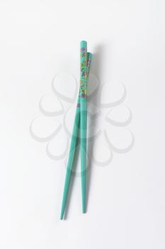 A pair of blue chopsticks with floral pattern