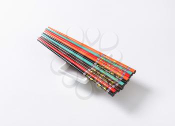 Set of colorful chopsticks with flower patterns on small white bowl