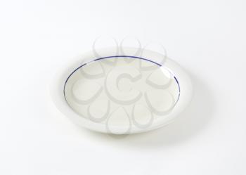 White shallow dinner plate with blue ring