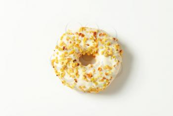 Glazed donut topped with chopped nuts