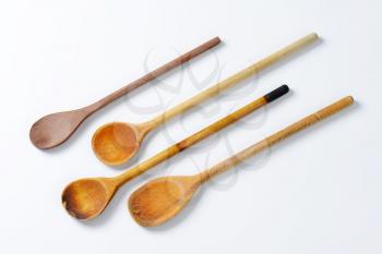four wooden spoons on off-white background