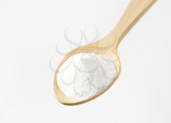 heap of cooking soda on wooden spoon