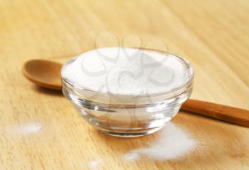 bowl of cooking soda and wooden spoon on table