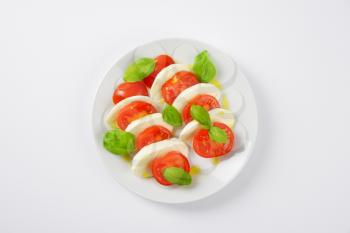plate of fresh caprese salad on white background