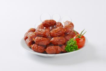 strings of mini cabanossi sausages on plate