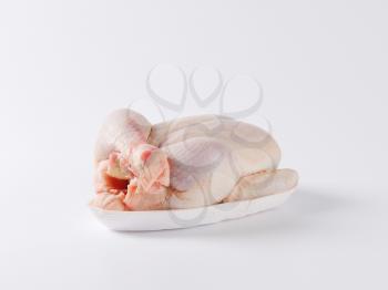 raw chicken with crossed legs