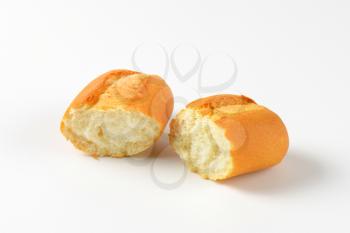 halved fresh bread roll on white background