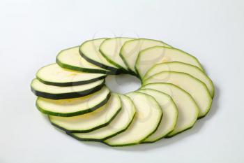 circle of thin slices of zucchini on a white background
