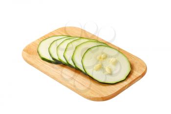 sliced zucchini on cutting board isolated on white