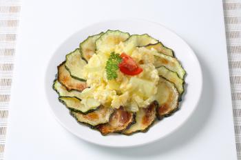 Roasted zucchini slices with potato and egg scramble