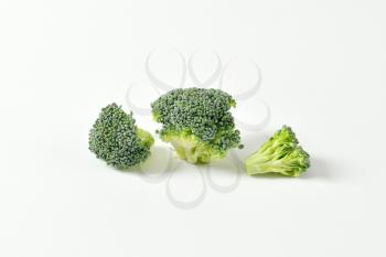 Fresh broccoli florets on off-white background