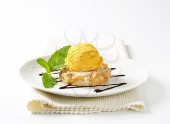 Almond cookie and scoop of ice cream served on a plate
