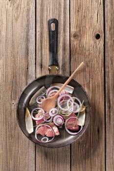 Pieces of meat and onion on frying pan