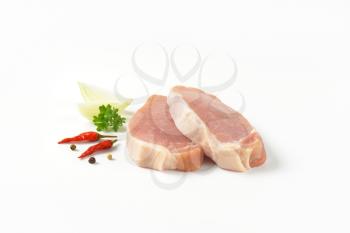 raw boneless pork loin chops on white background