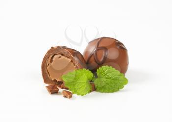 one and half belgian chocolate pralines on white background