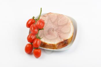 stack of ham slices and cherry tomatoes on white plate
