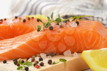 raw salmon fillets with salt, peppercorns, thyme and lemon
