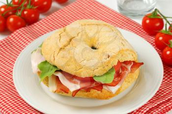 Ring-shaped bread roll with slices of prosciutto