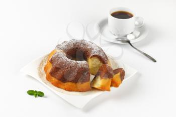 marble bundt cake and cup of black coffee on white background
