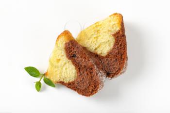 two slices of marble bundt cake on white background
