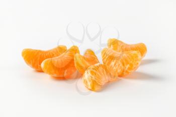 separated segments of tangerine on white background