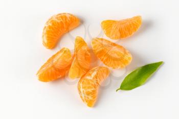 separated segments of tangerine on white background