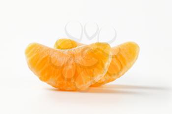 two separated segments of tangerine on white background