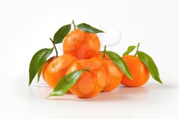 group of tangerines with leaves on white background