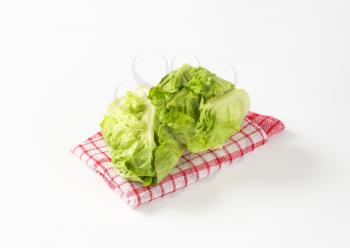 Fresh little gem lettuce heads on checked dish towel