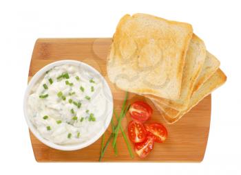 pile of toasted white bread slices and bowl of  creamy spread with chives