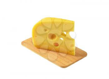 wedge of medium-hard Swiss cheese on cutting board