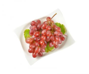 bunch of washed red grapes on white plate