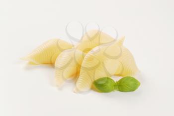 pile of cooked pasta shells on white background