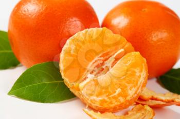 detail of fresh seedless tangerines - peeled and unpeeled