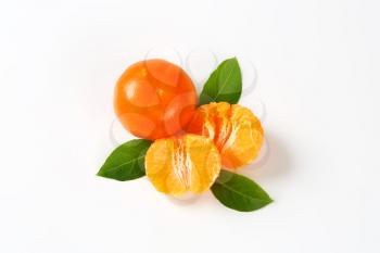 fresh tangerines peeled and unpeeled on white background